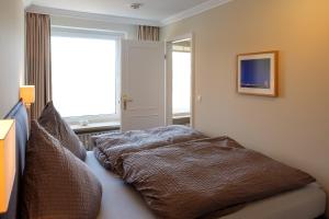 a bedroom with a bed with pillows on it at Sola Bona 24 in Westerland