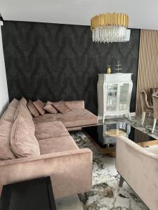 un soggiorno con divano e tavolo in vetro di Apartament Złoty 2 a Cieciorka