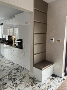 kuchnia z białymi szafkami i marmurową podłogą w obiekcie Apartament Złoty 2 w mieście Cieciorka