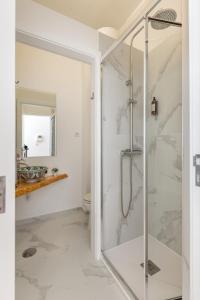 une salle de bain avec une douche avec une porte vitrée dans l'établissement Oporto Bonjardim Residence, à Porto 91 autres photos