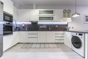 een keuken met witte kasten en een wasmachine en droger bij Vita Portucale ! Moscavide Family Apartment in Lissabon