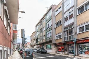 een straat met gebouwen en een auto op straat bij Vita Portucale ! Moscavide Family Apartment in Lissabon