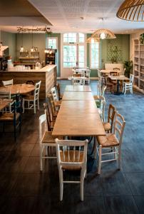 a dining room with wooden tables and chairs at La Maison du Gasseau in Saint-Léonard-des-Bois