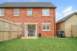 a red brick house with a wooden fence at Lovely 3 Bed Home for Colleagues in Darlington