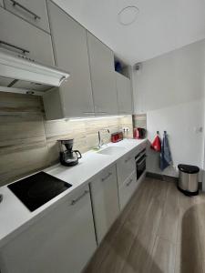 a small kitchen with white cabinets and a sink at Studio moderne - Port de Mandelieu - Proche Mer in Mandelieu-La Napoule