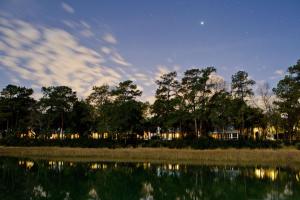a night view of a lake with trees and the moon at Montage Palmetto Bluff in Bluffton
