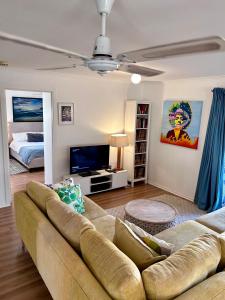 un soggiorno con un divano e un letto di Magic Beach Cottage a Venus Bay