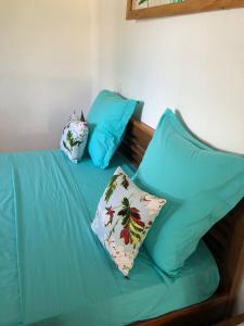 a blue bed with two pillows on top of it at Maison madasgascar in Ampasikely