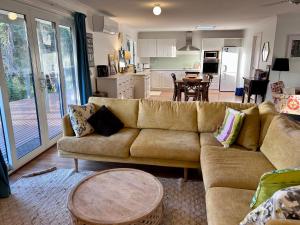 un soggiorno con divano e cucina di Magic Beach Cottage a Venus Bay