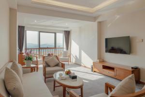 a living room with a couch and a tv at White Swan Guest House MeiZhou in Meizhou