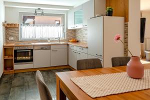 a kitchen with a table and a kitchen with a refrigerator at Alpski škrat, Kranjska Gora in Kranjska Gora