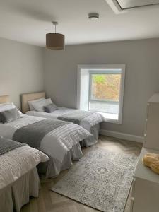 a bedroom with two beds and a window at Mary’s Seaview Clifden in Galway