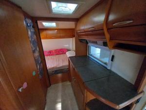 a small room with a kitchen and a bedroom at Caravan near the sea 6 in Ugljan