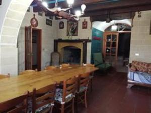 un grande tavolo in legno in una stanza con camino di Masseria Julia Salento a Corsano