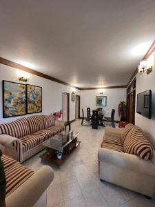 una gran sala de estar con sofás y una mesa. en Villa Bliss Lake View, en Nainital