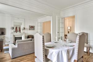 uma sala de jantar branca com uma mesa e cadeiras em Exceptional flat at the heart of Montmartre - Paris - Welkeys em Paris