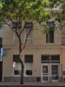 a hotel building with a tree in front of it at 1412 Hotel Boutique in Rosario