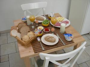 a wooden table topped with plates of food at Pension Kamperland in Kamperland