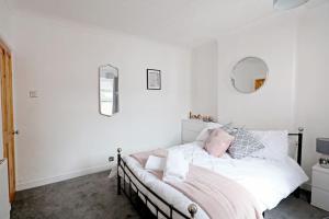 a white bedroom with a bed and a mirror at Cowgate Rest in Norwich