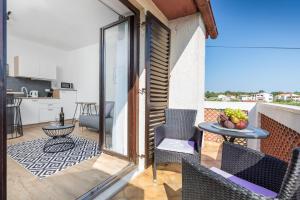 a balcony with a table and chairs and a kitchen at wine house apartments& rooms Marčeta in Fažana
