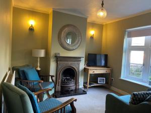 uma sala de estar com lareira e televisão em Demeter Cottage em Whitby