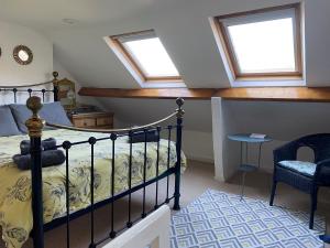 a bedroom with a bed and two windows at Demeter Cottage in Whitby