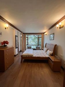 a bedroom with a bed and a large window at Villa Bliss Lake View in Nainital