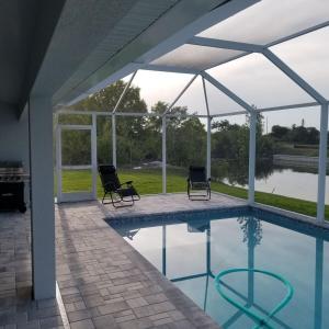 - une piscine avec 2 chaises et un pavillon dans l'établissement Stunning New Home in Cape Coral Florida, à Cape Coral