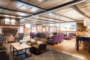 a lobby with purple chairs and a fireplace at Scandic Hafjell in Hafjell