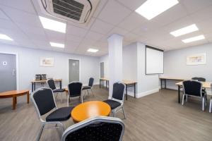 - une salle d'attente avec des chaises, une table et un tableau blanc dans l'établissement Comfort Inn Birmingham, à Birmingham