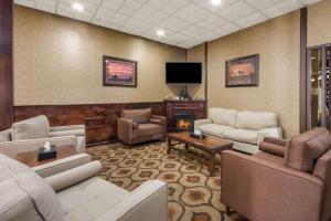 a living room with white furniture and a tv at Quality Inn in Chickasha