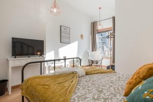 una camera con letto e TV a schermo piatto di Oporto Bonjardim Residence a Porto