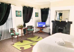 - une chambre avec un lit, une télévision et une cheminée dans l'établissement The Georgian Apartment, à Gosport