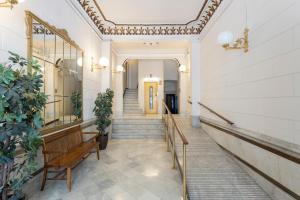 a hallway with a bench and stairs in a building at Feelathome Casa Bertrand in Barcelona