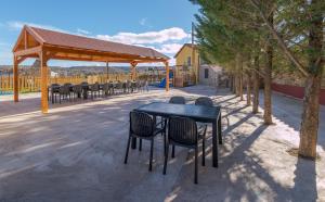 a black table and chairs under a pavilion with trees at CASA RURAL VICENTA 1750 in Albentosa