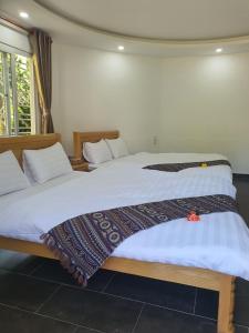 two beds sitting next to each other in a bedroom at LẠC DƯƠNG TIÊN CẢNH (BULGALOW) in Xuan An