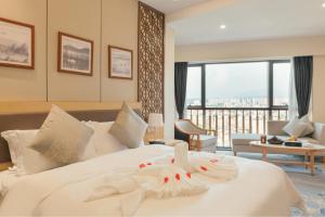 a bedroom with a large white bed with a view at White Swan Guest House MeiZhou in Meizhou