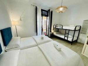 a white room with two beds and a bunk bed at Pension Venecia Gomerez in Granada