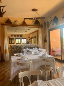 SeùloにあるHotel Miramonti Seulo Turismo Ruraleの白いテーブルと椅子、鏡のあるレストラン