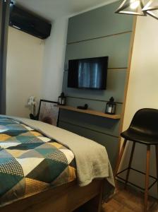 um quarto com uma cama e uma televisão de ecrã plano na parede em Studio Sunset em Voždivac