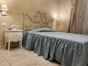 - une chambre avec un lit et une table de chevet avec un téléphone dans l'établissement Boutique Hotel Calais Milano, à Milan