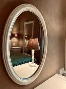 uno specchio con lampada di fronte a una camera da letto di Boutique Hotel Calais Milano a Milano