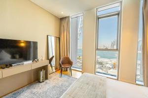 een hotelkamer met een tv en een groot raam bij FAM Living Bluewaters - Island Living - Ain Dubai & Sea View in Dubai