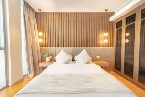 een slaapkamer met een groot wit bed met 2 kussens bij FAM Living Bluewaters - Island Living - Ain Dubai & Sea View in Dubai