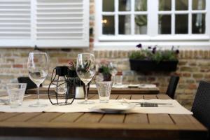 a wooden table with wine glasses on top of it at Amaryllis Hotel Veurne in Veurne