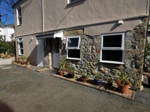 uma casa de pedra com vasos de plantas em frente em Sandsifter at 4 Trencrom Court, Carbis Bay,St Ives, Cornwall em Carbis Bay