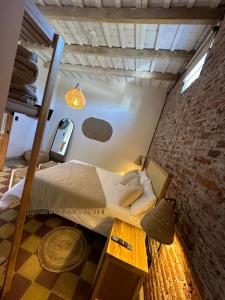 Cama en habitación con pared de ladrillo en Tanah Host - Casa de Huespedes en Villa Mercedes