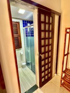 a bathroom with a shower and a glass door at Pousada HOME BEACH MAR porto das dunas BEACH PARK in Aquiraz
