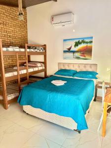a bedroom with a blue bed and bunk beds at Pousada HOME BEACH MAR porto das dunas BEACH PARK in Aquiraz