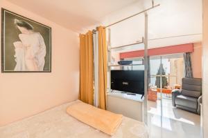 サン・ラファエルにあるApartment Boulourisのベッド、テレビ、窓が備わる客室です。